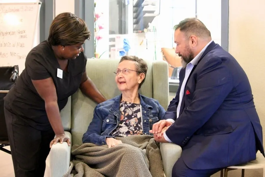 A caregiver with a resident and family member